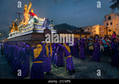 Antigua, Guatemala - 17 Avril 2014 : Penitens transportant un flotteur à l'image de Jésus Christ dans une procession de Pâques la nuit durant la Semaine Sainte en Banque D'Images