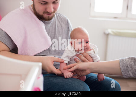 Jeune père de sa fille burping, tenant son affectueusement. Session familiale Lifestyle.. Banque D'Images