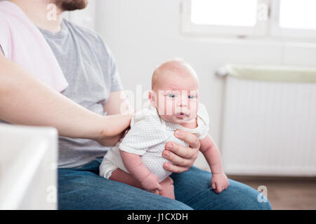 Jeune père de sa fille burping, tenant son affectueusement. Session familiale Lifestyle.. Banque D'Images