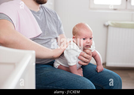 Jeune père de sa fille burping, tenant son affectueusement. Session familiale Lifestyle.. Banque D'Images