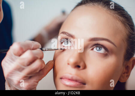 Professional make-up artist rend le maquillage des yeux du modèle. Concept de la beauté et de la mode. Close up. Banque D'Images