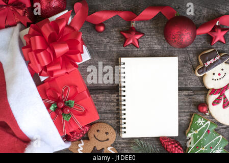Décorations de Noël de fond avec ruban rouge arc et des ornements et de l'ordinateur portable ouvert sur Vue de dessus de table en bois Banque D'Images