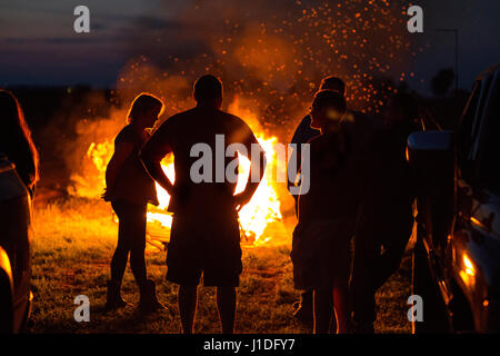 Les gens autour d'un feu de silhouette Banque D'Images