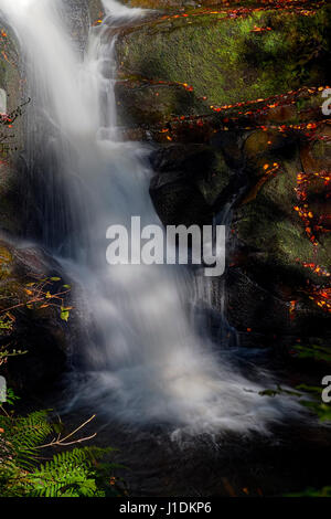 Une cascade est ralenti comme il coule dans une piscine dans les rochers. Banque D'Images