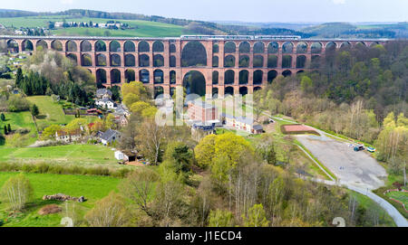 Un train traverse la Göltzsch Netzschkau viaduc en, Allemagne, 21 avril 2017. Le viaduc est le plus grand pont de chemin de fer en brique dans le monde. Il a été construit à l'aide de quelque 26 millions de briques et est de 78 mètres de haut et 574 mètres de long. Les visiteurs peuvent maintenant admirer le pont dans sa pleine gloire après vignes et arbustes couvrant partiellement le pont a été achevé. Photo : Jan Woitas/dpa-Zentralbild/dpa Banque D'Images