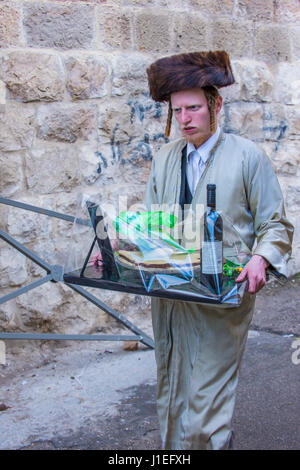 L'homme ultra-orthodoxe Mishloach Manot holding pendant Pourim À Mea Shearim à Jérusalem Banque D'Images