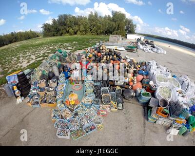 Les bénévoles avec la NOAA Marine Debris program posent avec une montagne de déchets en plastique, des moustiquaires et des débris marins recueillis à partir de l'atoll de Midway, le 15 février 2013 dans l'atoll de Midway, réfugiés de la faune. Les débris marins NOAA Programme supprime des milliers de livres de refuser chaque année de l'archipel. Banque D'Images