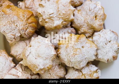 Profiteroles remplis de crème pâtissière et saupoudrée de sucre en poudre sur la restauration tableau bleu Banque D'Images