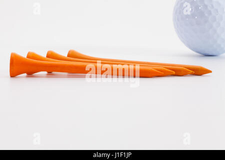 Golf tees en bois Orange et balle de golf sur le tableau blanc Banque D'Images