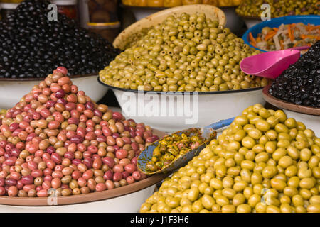 Échoppe de marché vendre olives fraîches et des bouteilles d'alimentation dans le principal souk de Marrakech, Maroc. Banque D'Images