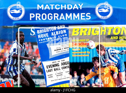 Des couvertures de magazines et de célèbres joueurs de football de Brighton et Hove Albion plaqué sur les programmes de la journée stand au stade Amex. Banque D'Images