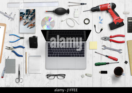 Matériel informatique service desk. Ordinateur portable avec écran blanc entouré d'outils de réparation. Vue d'en haut. Banque D'Images