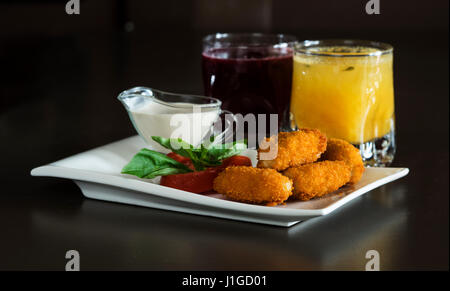 Menu enfant : nuggets de poulet croustillant à la tomate, basilic et à la crème sur une plaque blanche Banque D'Images