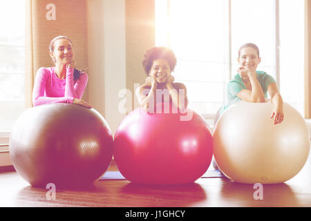 Group of smiling women avec des boules d'exercice dans la salle de sport Banque D'Images