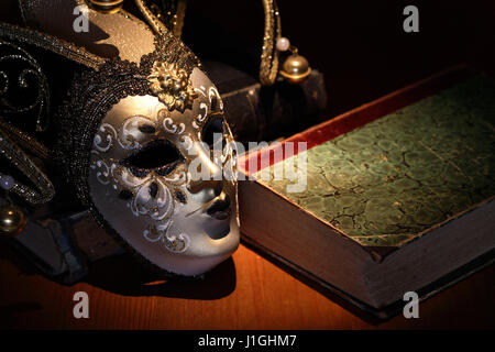 Vintage still life. Beau masque de Venise près de vieux livre Banque D'Images