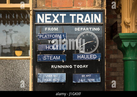 Un signe sur la plate-forme de train à vapeur de la ligne de pavot à Sheringham Norfolk montrant l'arrivée et de départ et l'horaire des trains Banque D'Images