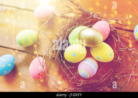 Close up of colored Easter eggs in nest sur bois Banque D'Images