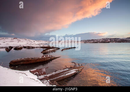 Cimetière de petits bateaux de pêche en Teriberke au lever du soleil. Région de Mourmansk, en Russie. Banque D'Images