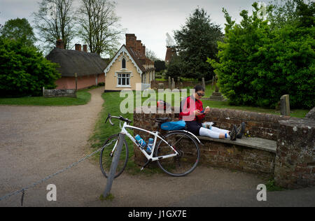 Thaxted Essex en Angleterre. 20 avril 2017. Au repos cycliste de prendre le déjeuner en Thaxted cimetière montrant John Webb et le moulin de Thaxted Hospice en background Banque D'Images