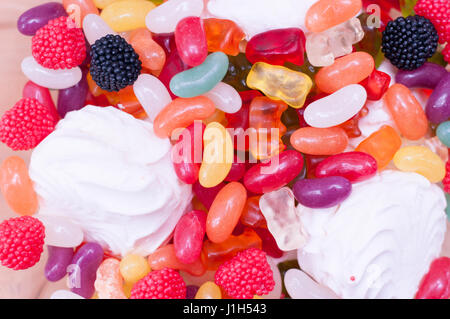 Ce vase en verre rempli de bonbons colorés et de gelées sur fond de bois Banque D'Images