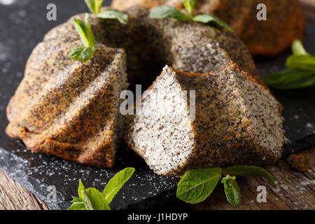 Tranche de gâteau bundt délicieux avec poppy et menthe libre sur la table horizontale. Banque D'Images