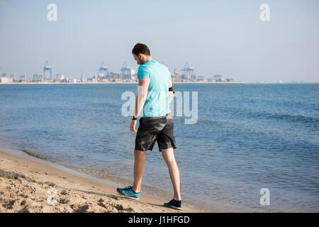 Homme fatigué après le jogging sur la plage Banque D'Images
