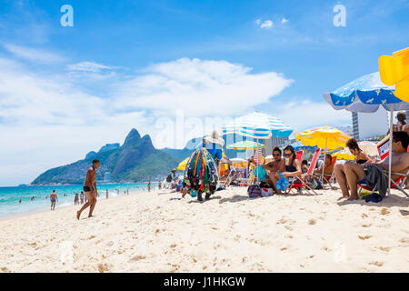 RIO DE JANEIRO - le 18 janvier 2017 : les vendeurs de plage plage pass se relâcher à l'ombre des parasols sur une chaude après-midi d'été à Ipanema. Banque D'Images