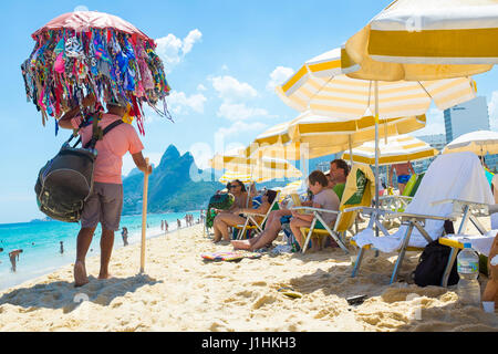 RIO DE JANEIRO - le 24 janvier 2017 : les vendeurs de plage plage pass se relâcher à l'ombre des parasols sur une chaude après-midi d'été à Ipanema. Banque D'Images