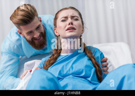 Femme enceinte, donnant naissance à l'hôpital pendant que man hugging her Banque D'Images