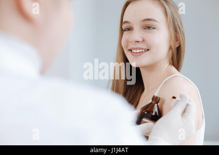 Adolescent amusé appréciant visite au dermatologue à la clinique Banque D'Images