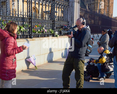 Le tournage de presse interview à côté de tributs floraux après l'attaque terroriste de Westminster, la place du Parlement, Londres, Angleterre Banque D'Images