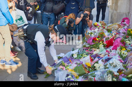 Policewoman apporter des fleurs pour les victimes de l'attaque terroriste de Westminster, Londres, Angleterre Banque D'Images