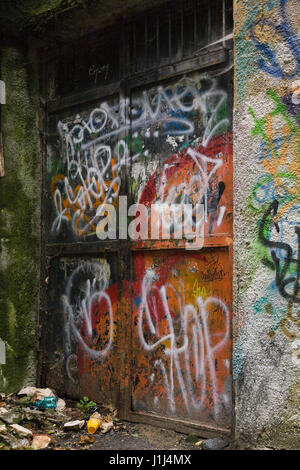 Corbeille et graffiti sur les portes arrière et le mur d'un bâtiment, Brasov, Roumanie, Europe de l'Est Banque D'Images