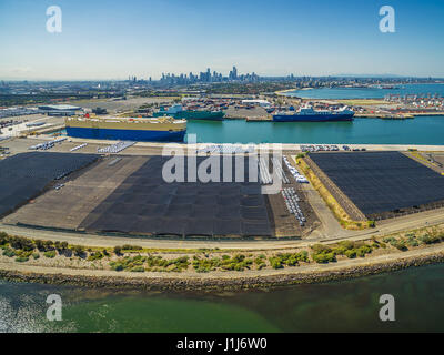 Grand transporteur de voiture et d'autres navires ont accosté au port de Melbourne CBD skyline sur l'horizon. Melbourne, Victoria, Australie Banque D'Images