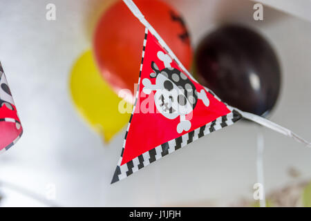 Les garçons à l'intérieur de la bannière de fête d'anniversaire pirate décoration. Banque D'Images