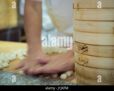 Dim sum panier de bambou avec des contenants d'un chef d'arrière-plan flou Banque D'Images