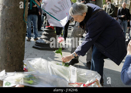 Paris, France. 21 avril 2017. Un mwoan jette des fleurs au Mémorial de fortune. Le lendemain de l'ISIS de tirer sur les Champs-Elysées qui a vu un policier mort, voit revenir à Paris d'affaires quotidiennes, mais avec forte présence policière sur les principaux sites. Crédit : Michael Debets/Alamy Live News Banque D'Images