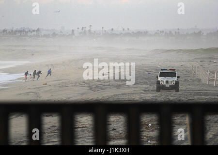 Tijuana, Baja Norte, Mexique. Feb 22, 2017. La Customs and Border Patrol Jeep fait face à la frontière américano-mexicaine mur comme un groupe de touristes dans l'arrière-plan tente de dépasser l'arrivée d'un vague de l'océan Pacifique. Le mur délimitant les États-Unis du Mexique traverse la ville de Tijuana, au-dessus des collines jusqu'à l'eau par Imperial Beach, CA. Puis il exécute près de deux mille milles à Brownsville, Texas. Crédit : John Gastaldo/ZUMA/Alamy Fil Live News Banque D'Images