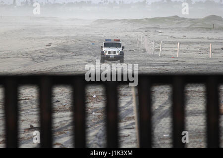 Tijuana, Baja Norte, Mexique. Feb 22, 2017. La Customs and Border Patrol Jeep fait face à la frontière américano-mexicaine à la frontière du mur du parc d'État sur le terrain comme un groupe de touristes dans l'arrière-plan tente de dépasser l'arrivée d'un vague de l'océan Pacifique. Le mur délimitant les États-Unis du Mexique traverse la ville de Tijuana, au-dessus des collines jusqu'à l'eau par Imperial Beach, CA. Puis il exécute près de deux mille milles à Brownsville, Texas. Crédit : John Gastaldo/ZUMA/Alamy Fil Live News Banque D'Images