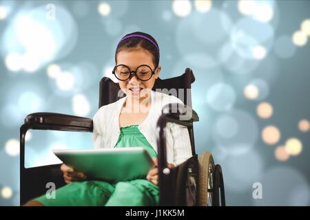 Digital composite of Girl in wheelchair using digital tablet Banque D'Images
