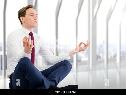 Digital composite of business man meditating contre fenêtre blanc floue Banque D'Images