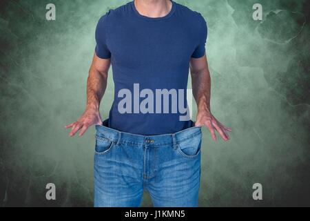 Portrait de l'homme de porter des jeans contre un arrière-plan vert Banque D'Images