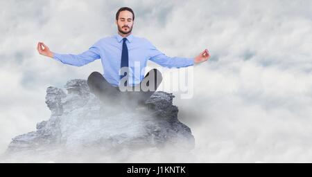 Digital composite de l'homme d'affaires méditant sur sommet de montagne dans les nuages Banque D'Images