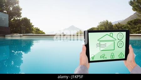 Digital composite des mains à l'aide de smart home app at poolside Banque D'Images