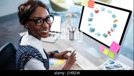 Digital composite of Happy businesswoman using computer avec divers graphiques Banque D'Images