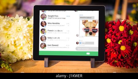 Composite numérique des médias sociaux page sur tablette numérique par des fleurs Banque D'Images