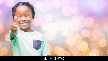 Digital composite de Happy girl showing Thumbs up sur bokeh Banque D'Images