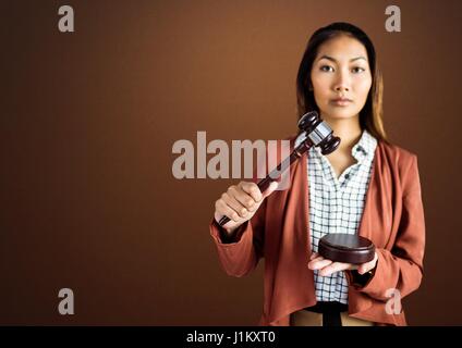 Digital composite du juge avec balance et d'un marteau en face de fond brun Banque D'Images