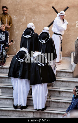 TARANTO, ITALIE - 13-14 avril 2017 : chaque année, les rites de Pâques aura lieu à Tarente. Le Jeudi saint et le vendredi, les membres des fraternités s'habillent de robes blanches, couvrant leurs visages avec les capots avec seulement deux fentes pour les yeux, qui les rendent méconnaissables. À la suite d'une ancienne route à travers la ville, des fraternités marcher pieds nus, portant la lourde statues représentant le chemin de croix jusqu'à l'aube. Banque D'Images