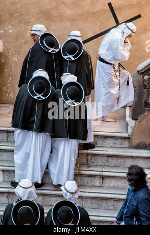 TARANTO, ITALIE - 13-14 avril 2017 : chaque année, les rites de Pâques aura lieu à Tarente. Le Jeudi saint et le vendredi, les membres des fraternités s'habillent de robes blanches, couvrant leurs visages avec les capots avec seulement deux fentes pour les yeux, qui les rendent méconnaissables. À la suite d'une ancienne route à travers la ville, des fraternités marcher pieds nus, portant la lourde statues représentant le chemin de croix jusqu'à l'aube. Banque D'Images